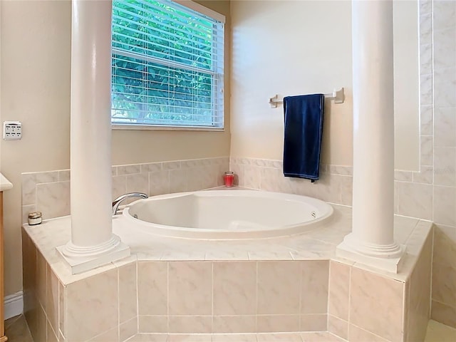 bathroom featuring a garden tub and ornate columns