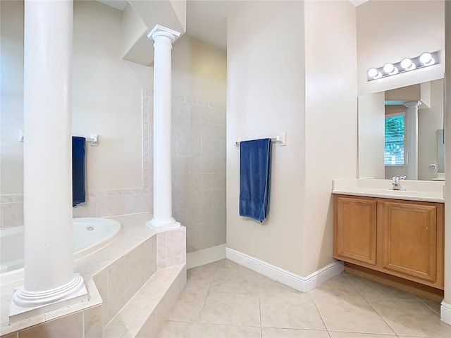 full bathroom with tile patterned flooring, vanity, a garden tub, and decorative columns