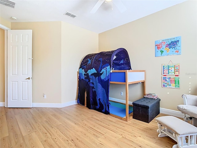 bedroom with visible vents, a ceiling fan, baseboards, and wood finished floors