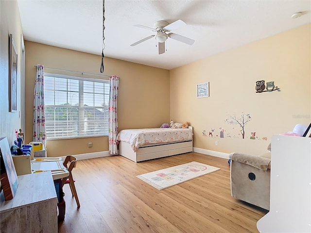 bedroom featuring a ceiling fan, baseboards, and wood finished floors