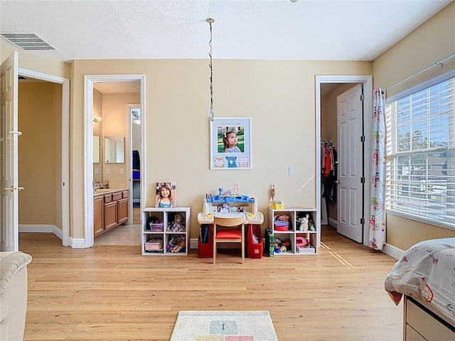 playroom with visible vents, baseboards, and light wood-style floors