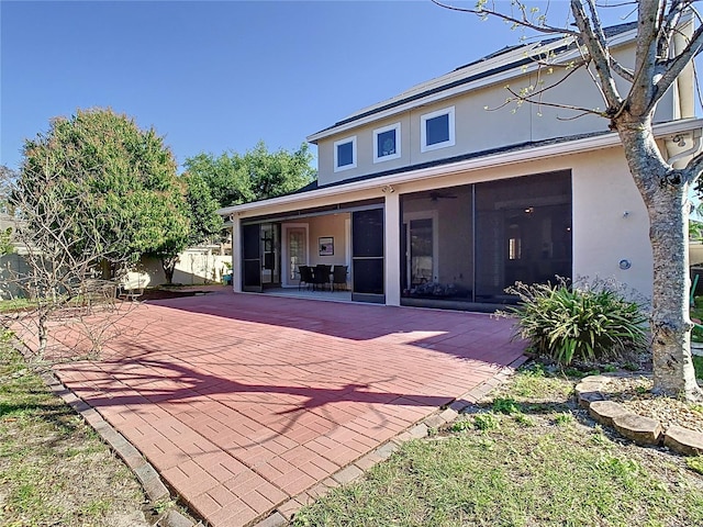 back of property featuring a patio area, fence, a sunroom, and stucco siding