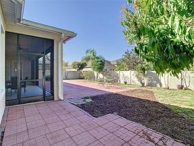 view of patio featuring a fenced backyard and a sunroom