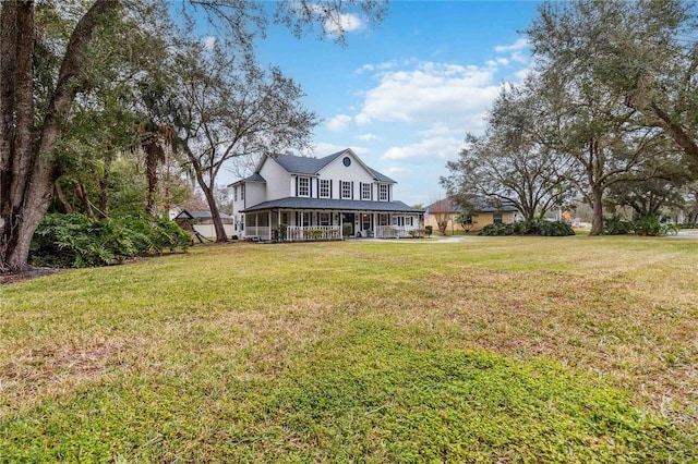 exterior space with covered porch and a yard