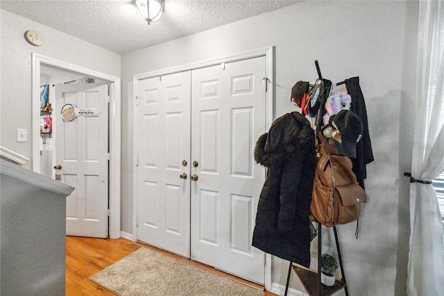 foyer entrance featuring a textured ceiling and light wood-type flooring