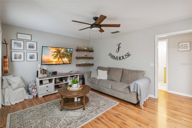 living area with visible vents, baseboards, ceiling fan, and wood finished floors