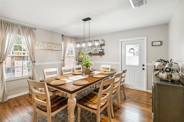 dining area featuring visible vents, baseboards, and hardwood / wood-style floors