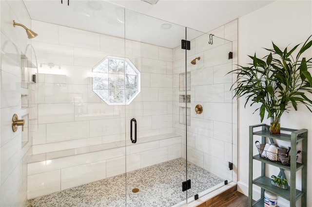 full bathroom featuring wood finished floors and a stall shower