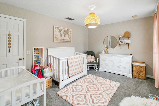 carpeted bedroom featuring a nursery area and visible vents