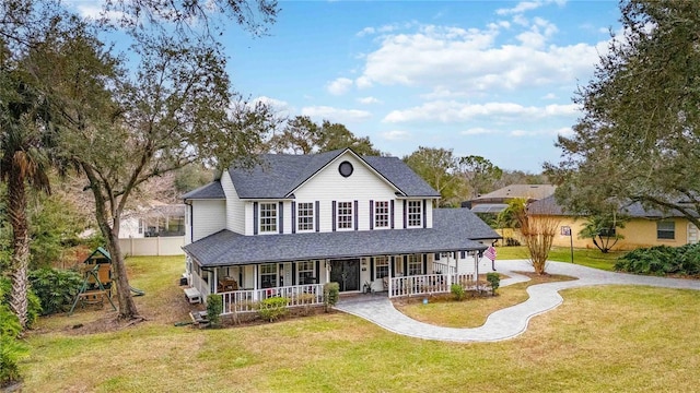 country-style home with a front lawn, covered porch, driveway, and a shingled roof