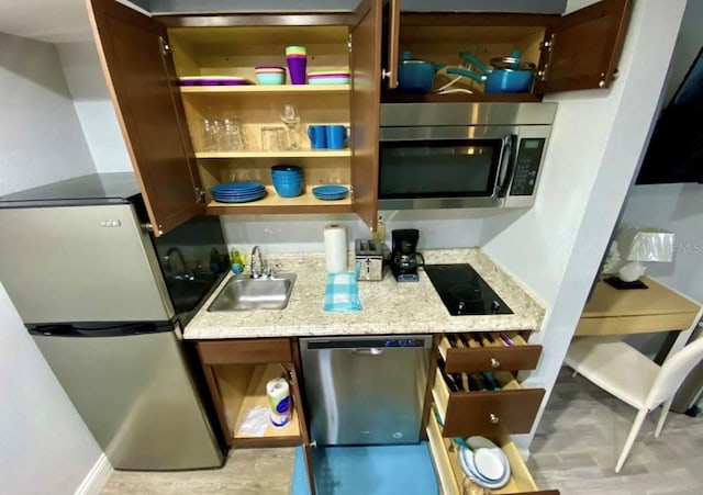 kitchen featuring light stone counters, baseboards, open shelves, a sink, and stainless steel appliances