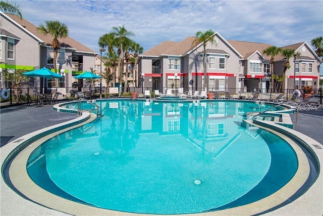 view of swimming pool with a residential view and fence