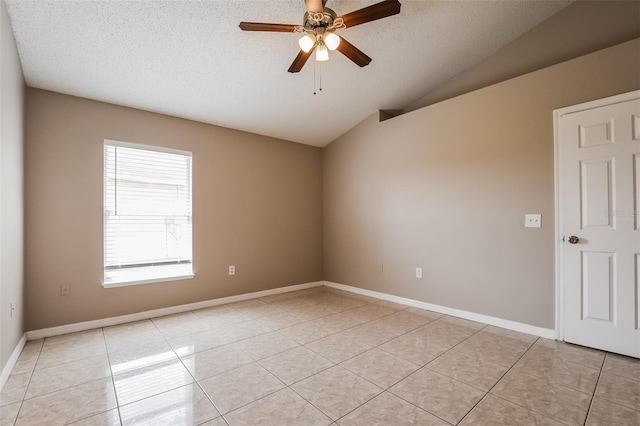 spare room featuring light tile patterned flooring, ceiling fan, a textured ceiling, and lofted ceiling