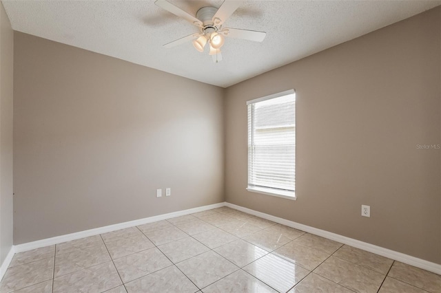 unfurnished room featuring light tile patterned flooring, a ceiling fan, baseboards, and a textured ceiling