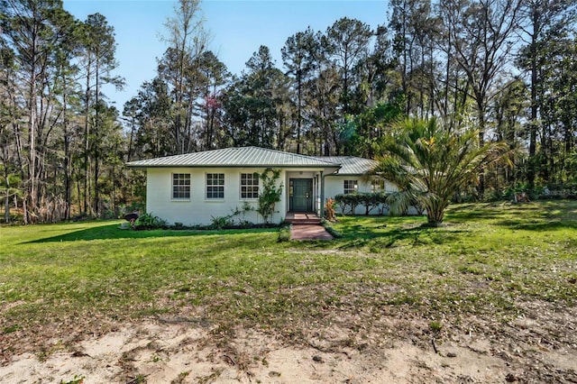 single story home with metal roof, a front lawn, and a standing seam roof