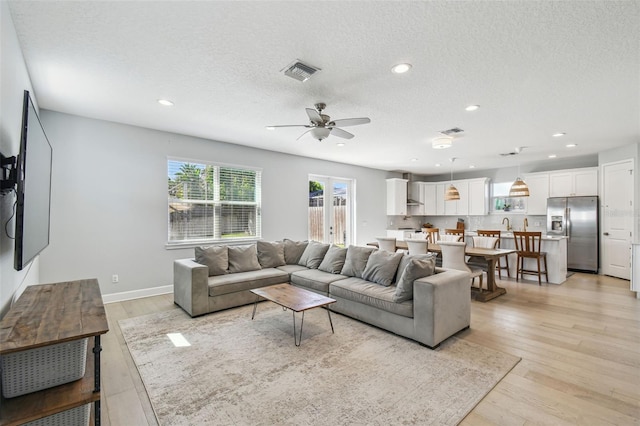 living room with light wood-type flooring, recessed lighting, visible vents, and ceiling fan