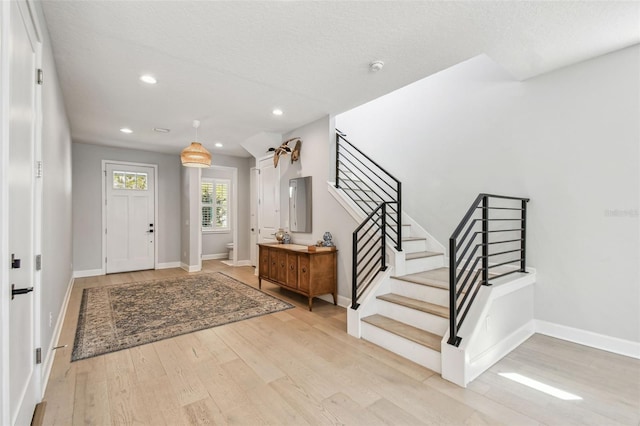 entryway featuring recessed lighting, stairway, baseboards, and wood finished floors