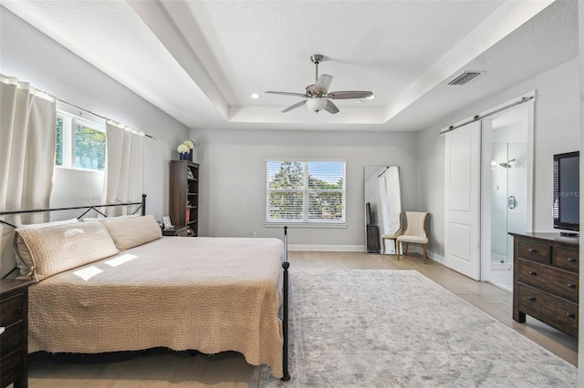 bedroom featuring visible vents, a ceiling fan, a tray ceiling, recessed lighting, and baseboards