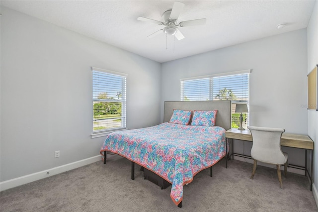 carpeted bedroom featuring baseboards and a ceiling fan