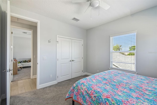 carpeted bedroom with a ceiling fan, baseboards, visible vents, and a closet