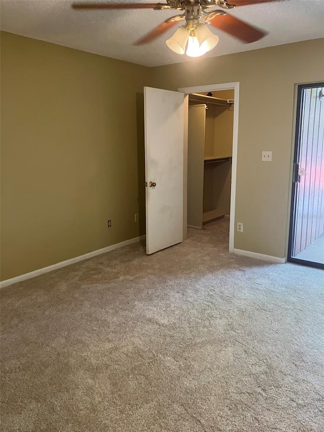 unfurnished bedroom with baseboards, carpet floors, ceiling fan, a closet, and a textured ceiling