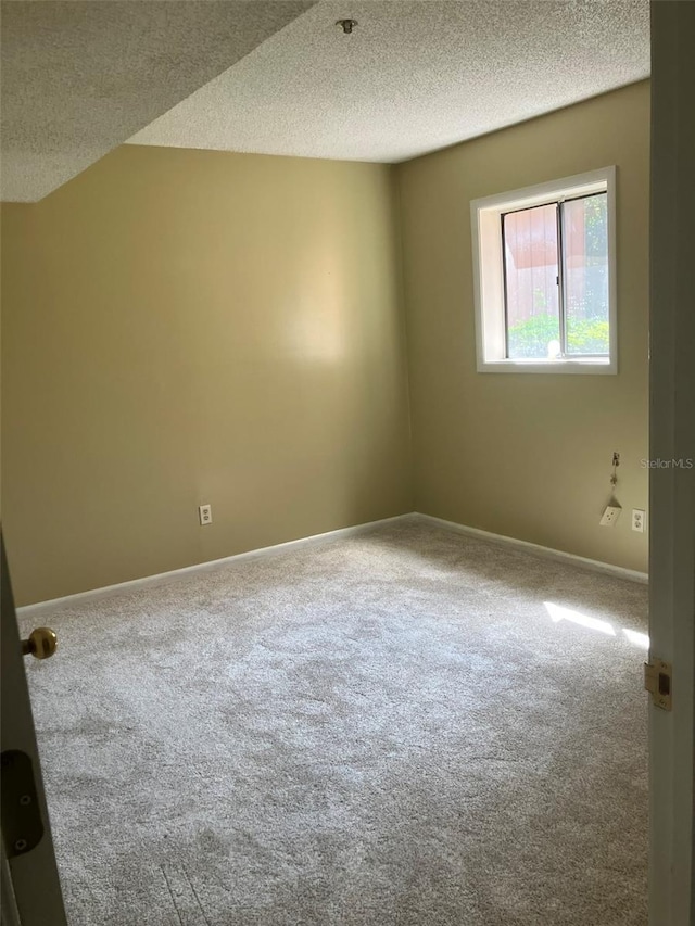 empty room with baseboards, carpet floors, and a textured ceiling