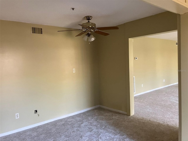 carpeted spare room featuring visible vents, a ceiling fan, and baseboards