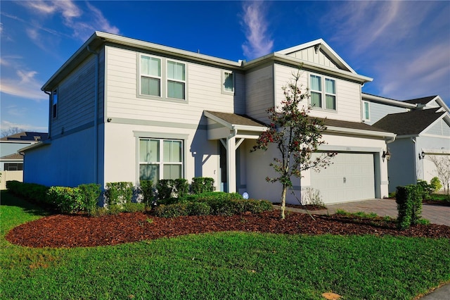 view of front of house with an attached garage, driveway, and a front lawn