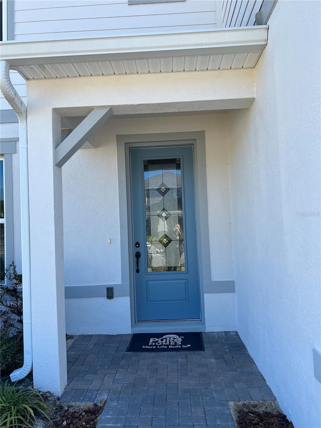 view of exterior entry with stucco siding