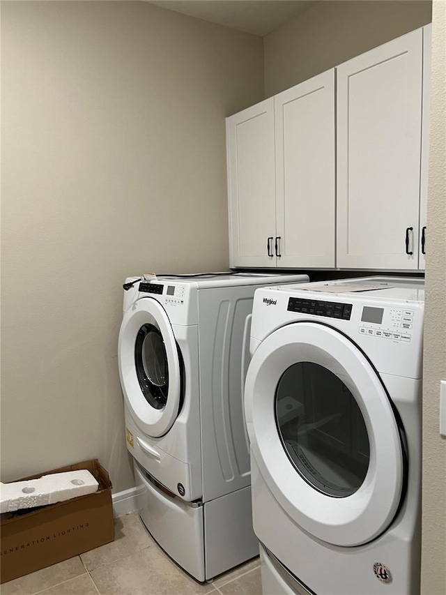 washroom with light tile patterned floors, cabinet space, and independent washer and dryer