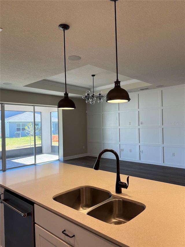 kitchen featuring a sink, light countertops, white cabinets, a textured ceiling, and dishwasher