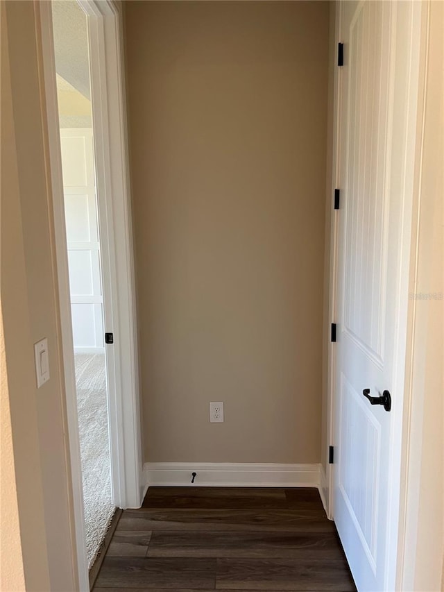 unfurnished room with baseboards and dark wood-style floors