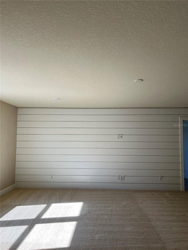 carpeted empty room featuring a textured ceiling