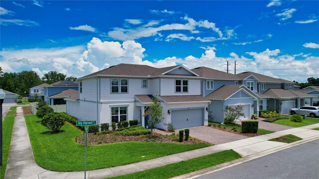 2313 Ivy Harvest Pl, Oviedo, FL 32765 - townhome / multi-family property featuring driveway, a residential view, a front yard, a garage, and stucco siding