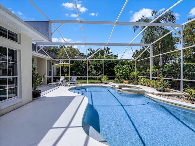 view of swimming pool featuring a patio, a lanai, and a pool with connected hot tub