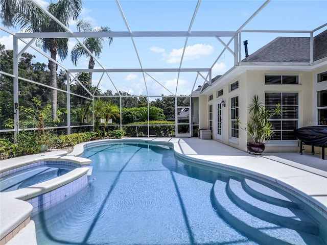 view of swimming pool with glass enclosure, a patio, and a pool with connected hot tub