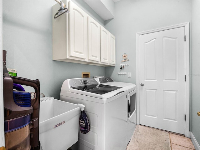 laundry room with cabinet space, independent washer and dryer, and a sink