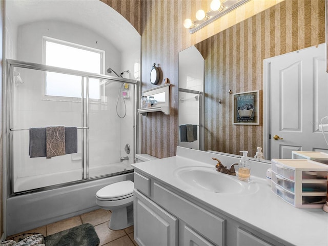 bathroom featuring tile patterned floors, wallpapered walls, and shower / bath combination with glass door