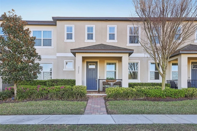 townhome / multi-family property with stucco siding and covered porch