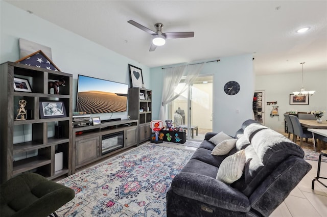 living room featuring light tile patterned floors and ceiling fan with notable chandelier