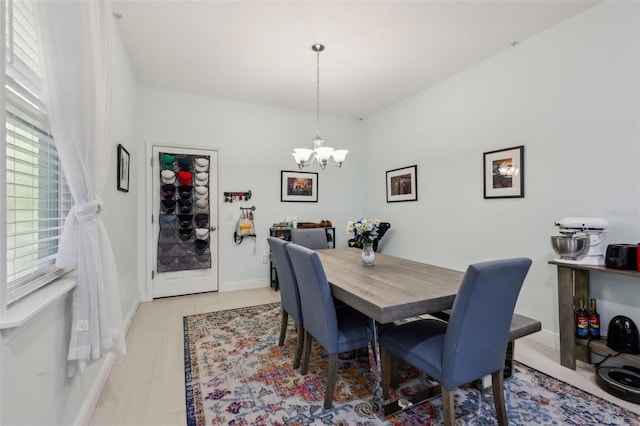 dining area with a notable chandelier, light wood-style floors, and baseboards