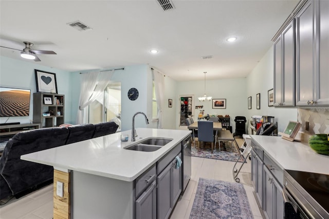 kitchen featuring visible vents, gray cabinetry, a sink, light countertops, and open floor plan