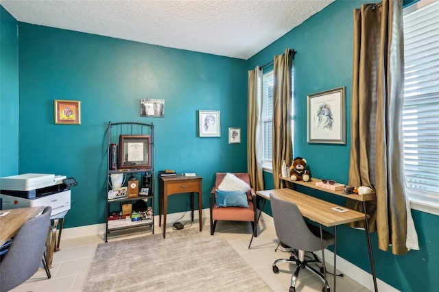 office space featuring tile patterned floors, baseboards, and a textured ceiling