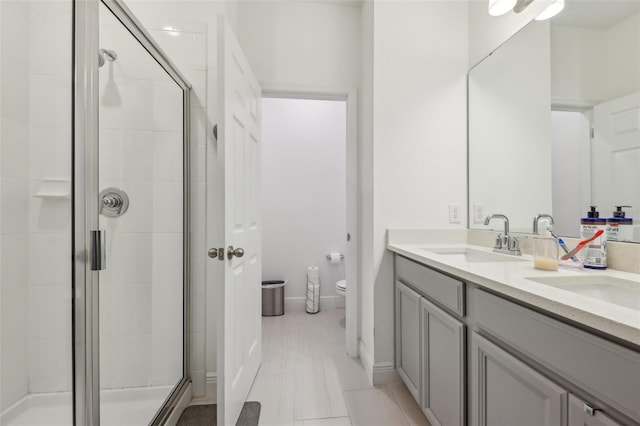 full bathroom with a shower stall, toilet, and a sink