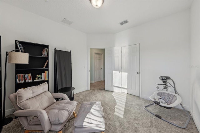 sitting room with visible vents, baseboards, and carpet floors