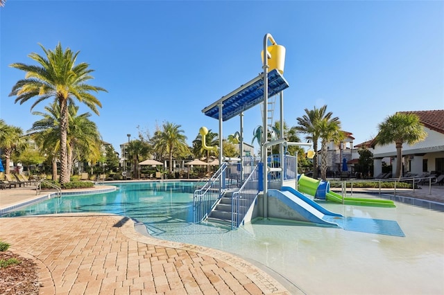 view of pool with playground community, a water slide, and a water play area