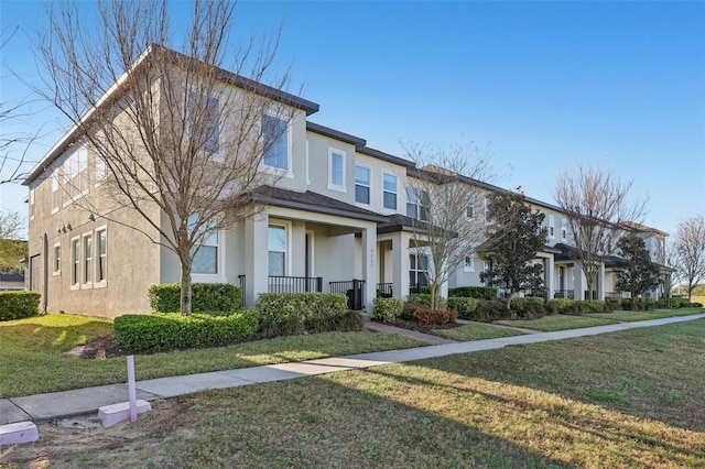 townhome / multi-family property with a front yard and stucco siding