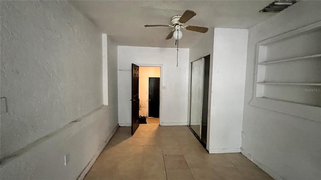 corridor with built in features, baseboards, and visible vents