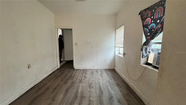 empty room featuring visible vents, cooling unit, wood finished floors, and baseboards