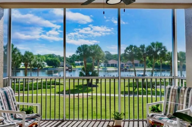 sunroom featuring plenty of natural light, a water view, and ceiling fan